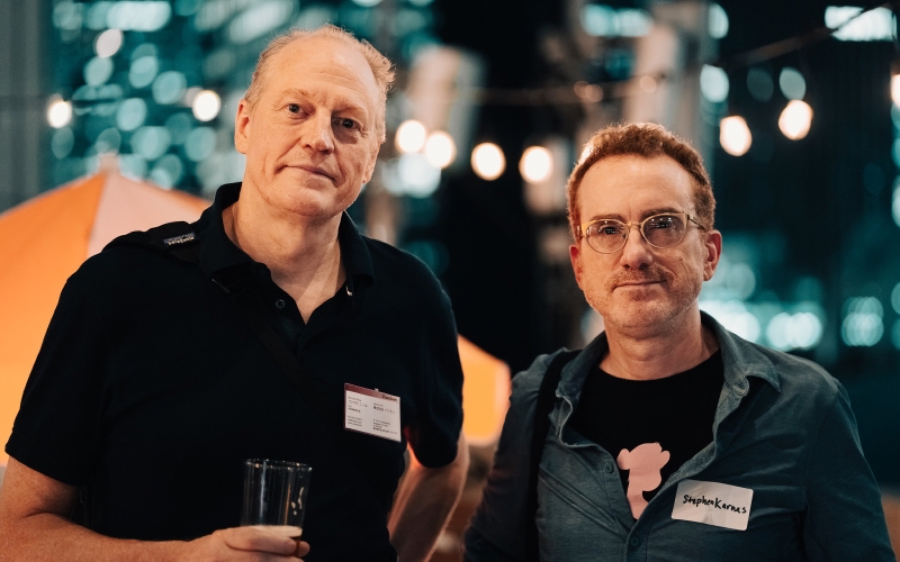 Two guests in conversation at a rooftop reception in Tokyo